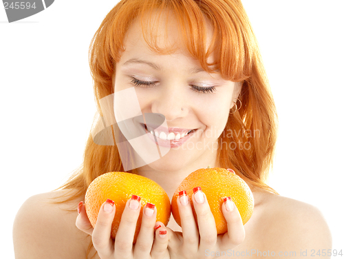 Image of cheerful redhead holding two oranges over white