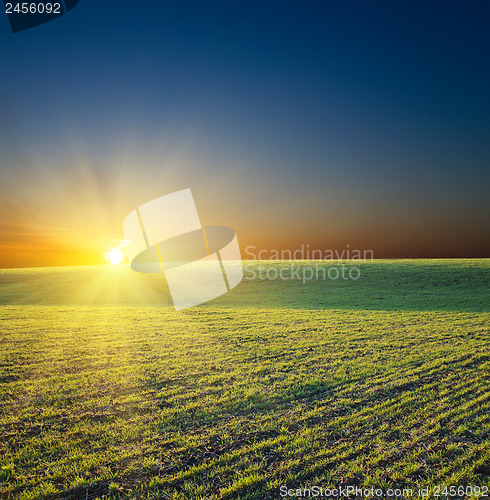 Image of sunset over green field