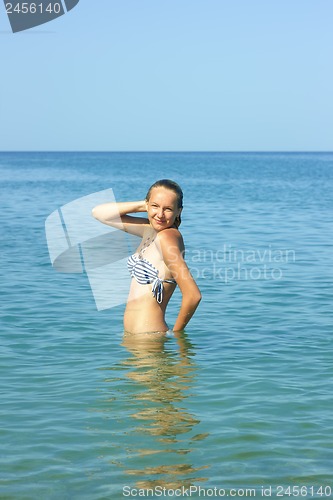 Image of Teenage girl standing waist-deep in seawater