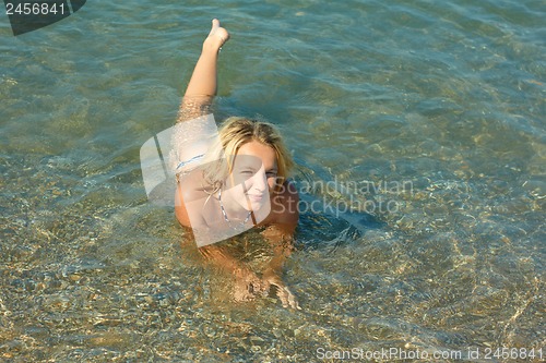 Image of Teenage girl lying in sea water