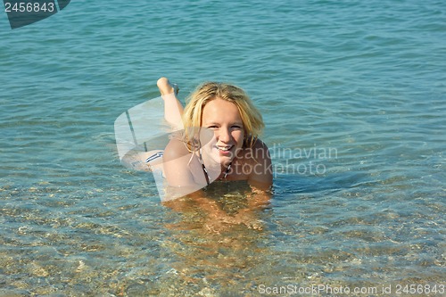 Image of Teenage girl lying in coastal seawater