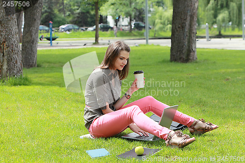Image of Young Woman with Computer in an Urban Park