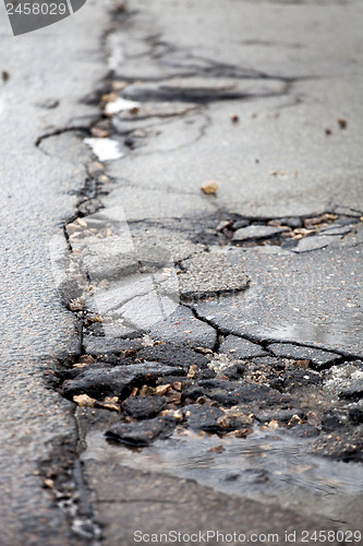 Image of Broken pavement and pothole asphalt road after winter.