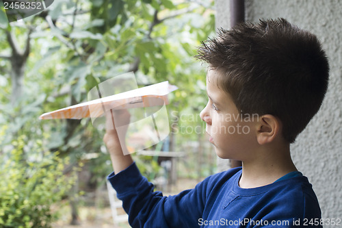 Image of Kid throws paper plane