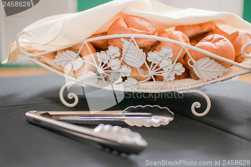 Image of Tasty rolls lying on a white napkin in a basket