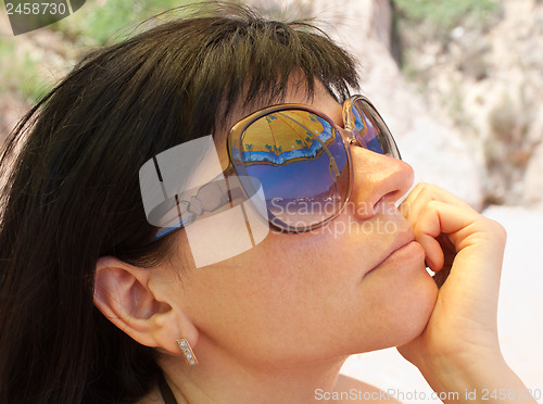 Image of Woman wearing sunglasses with beach mirroring