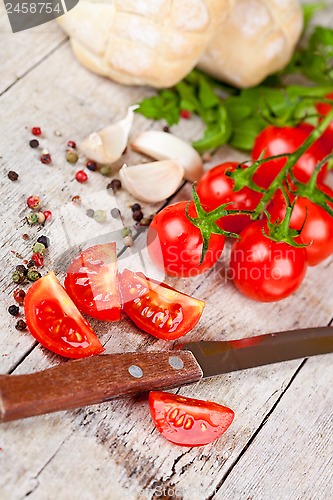 Image of fresh tomatoes, buns, spices and old knife 