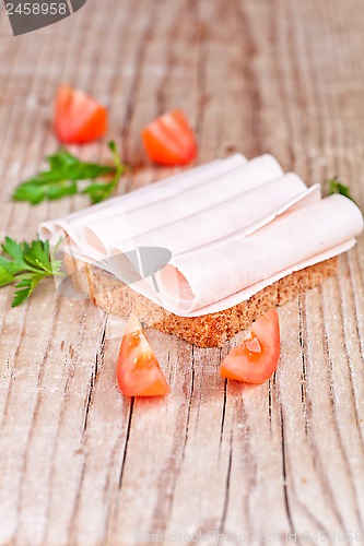 Image of bread with sliced ham, fresh tomatoes and parsley 