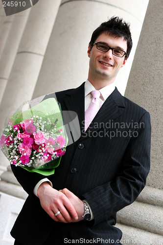 Image of Happy man with flowers under his arm