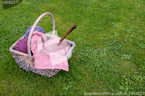 Image of Basket of knitting, needles and wool on a lawn