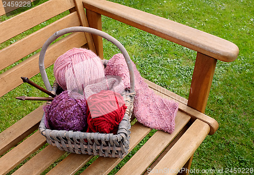 Image of Basket of knitting and yarns on a bench