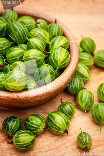 Image of Close-Up Of Gooseberries In Vintage Wooden Bowl On Wooden Table