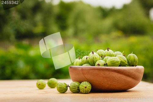 Image of Close-Up Of Gooseberries In Vintage Wooden Bowl On Wooden Table