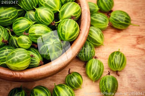 Image of Close-Up Of Gooseberries In Vintage Wooden Bowl On Wooden Table