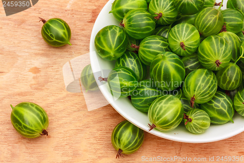 Image of Close-Up Of Gooseberries In Vintage White Dish On Wooden Table