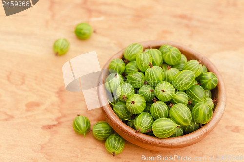 Image of Close-Up Of Gooseberries In Vintage Wooden Bowl On Wooden Table