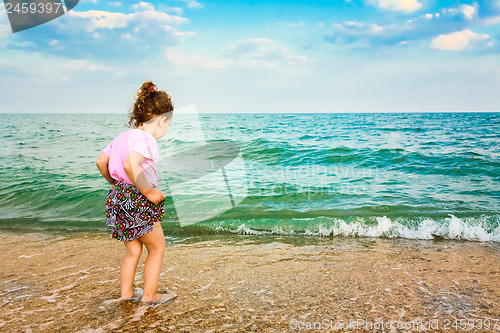 Image of Child running on water at ocean beach.