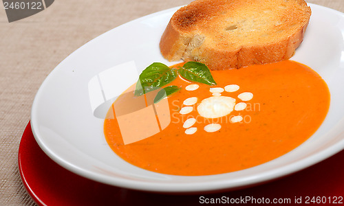 Image of Delicious bowl of tomato soup with grilled bread and basil