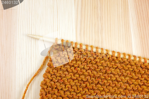 Image of Garter stitch in orange yarn on a knitting needle