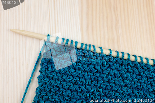 Image of Garter stitch in teal yarn on knitting needle