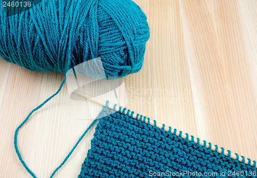 Image of Ball of blue wool with knitting on the needle