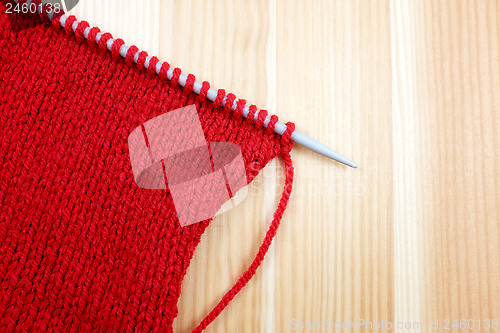 Image of Stocking stitch in red wool on a knitting needle