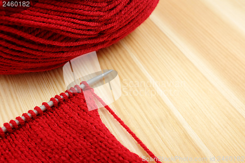 Image of Stockinette stitch on knitting needle with red wool