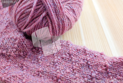 Image of Patterned knitting with ball of pink yarn