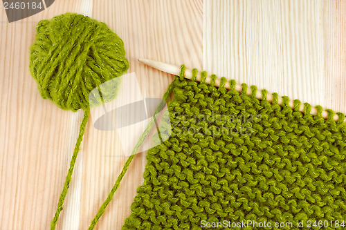 Image of Green wool and garter stitch on knitting needle