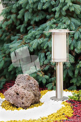 Image of Solar-powered lamp on garden background.