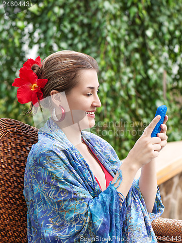 Image of Portrait of smiling beautiful woman texting with her phone.