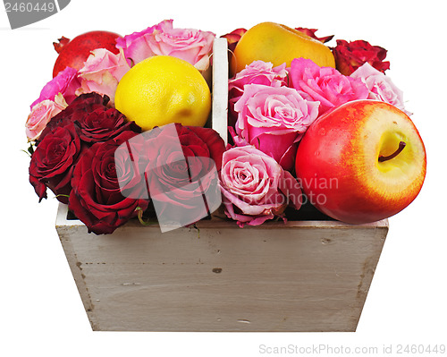 Image of Flower arrangement of red roses and fruits in wooden basket isol