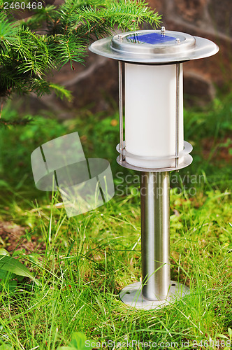 Image of Solar-powered lamp on garden background.