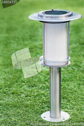 Image of Solar-powered lamp on green grass background. 