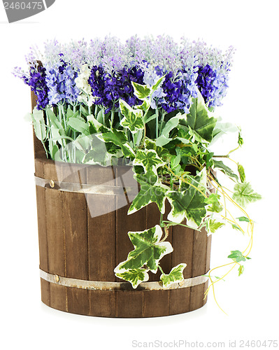 Image of Composition of artificial flowers in old wooden barrel isolated 