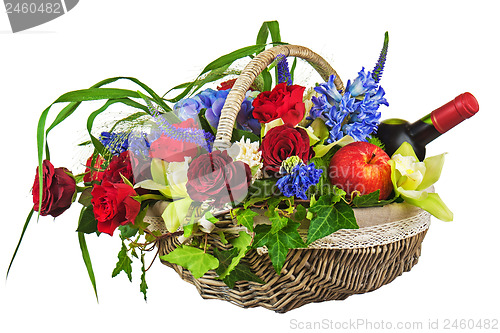 Image of Flower arrangement of roses, orchids, fruits and bottle of wine 
