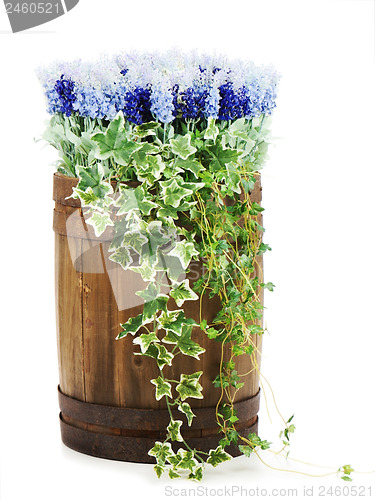 Image of Composition of artificial flowers in old wooden barrel isolated 