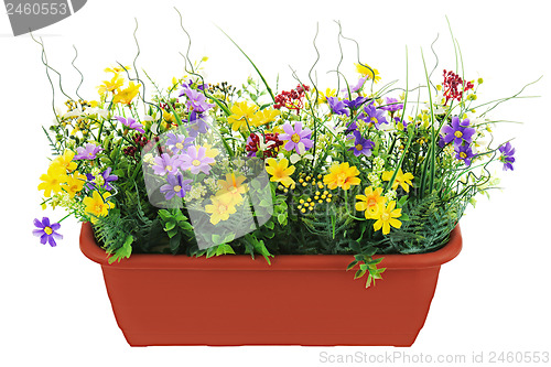 Image of Composition of artificial garden flowers in brown flowerpot isol