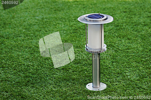 Image of Solar-powered lamp on green grass background.