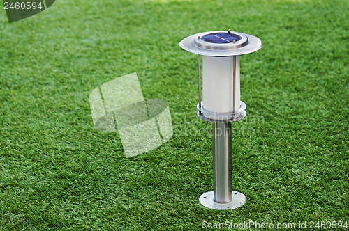 Image of Solar-powered lamp on green grass background.
