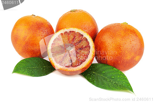 Image of Ripe red blood oranges with cut and green leaves isolated on whi