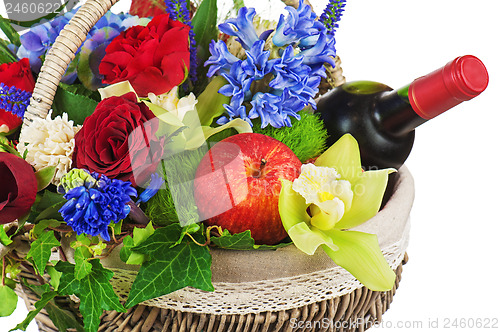 Image of Flower arrangement of roses, orchids, fruits and bottle of wine 