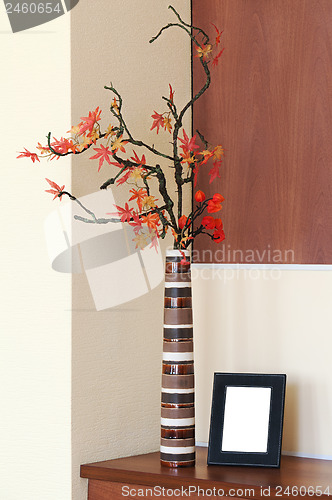 Image of Autumn arrangement in a vase on the table and photoframe.