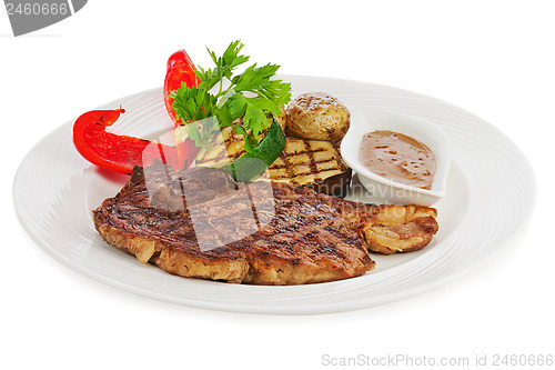 Image of Grilled steaks, baked potatoes and vegetables on white plate.