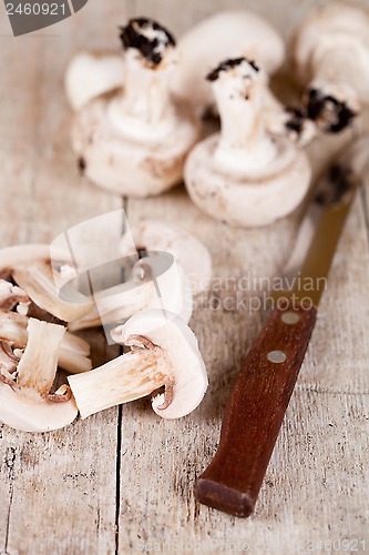 Image of  fresh sliced champignons and old knife 