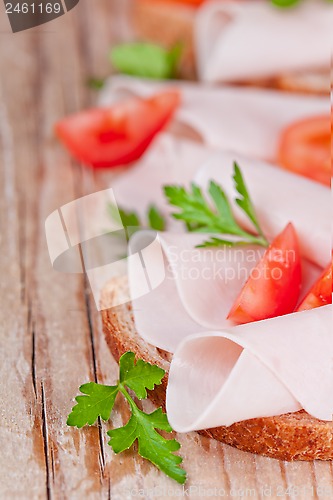 Image of bread with sliced ham, fresh tomatoes and parsley 