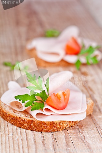 Image of bread with sliced ham, fresh tomatoes and parsley 