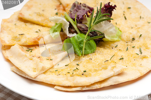 Image of garlic pita bread pizza with salad on top