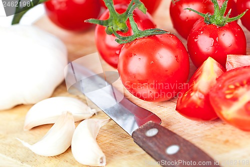 Image of fresh tomatoes, garlic and old knife