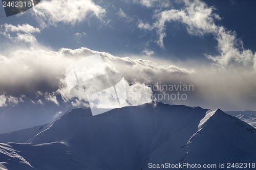 Image of Mountains in evening and sunlit clouds